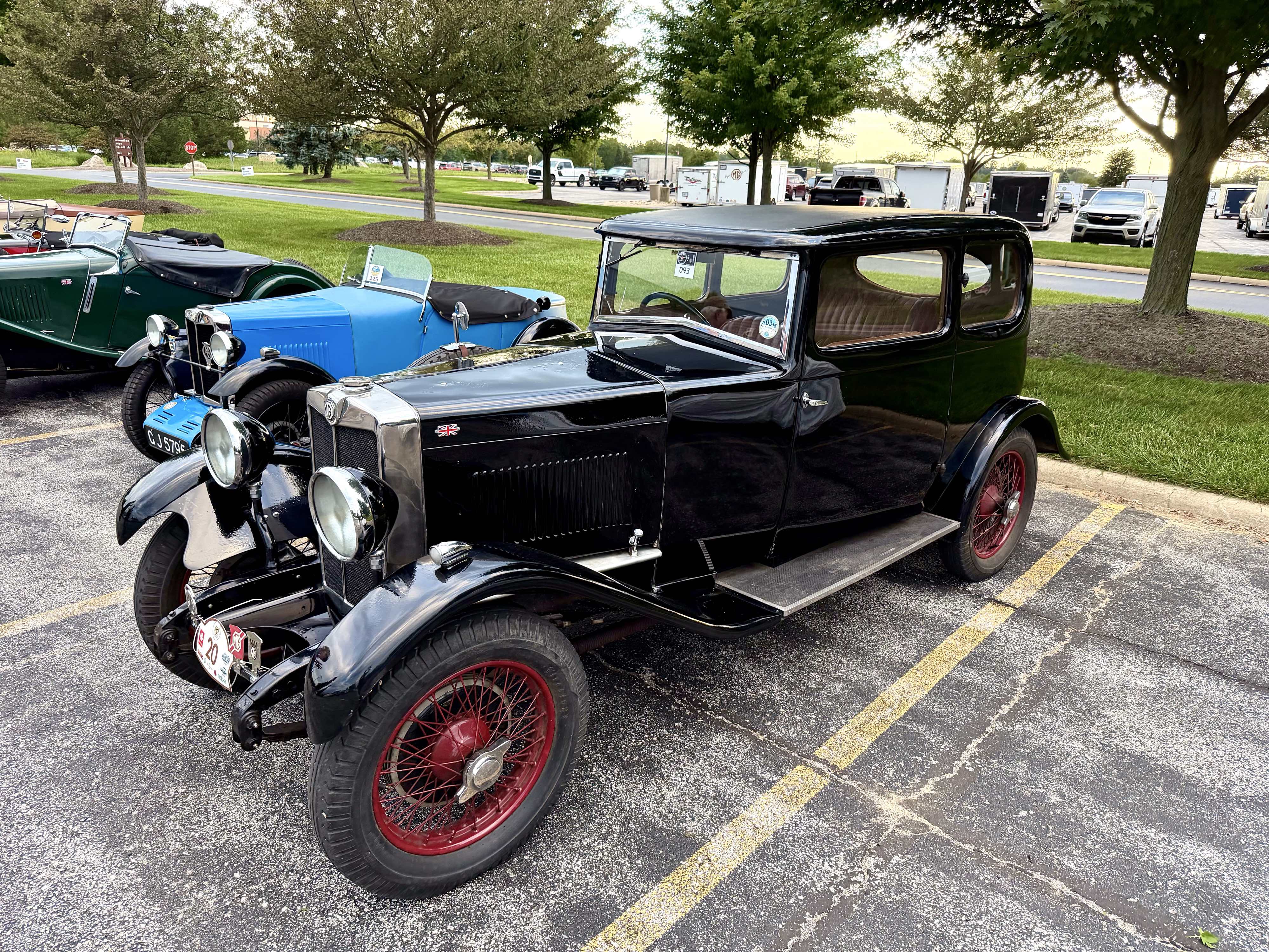 Photograph of a large black pre-World War Two MG six-cylinder coupe in front of a very small little blue 1930 MG M-Type roadster at the MG International 2026 gathering.