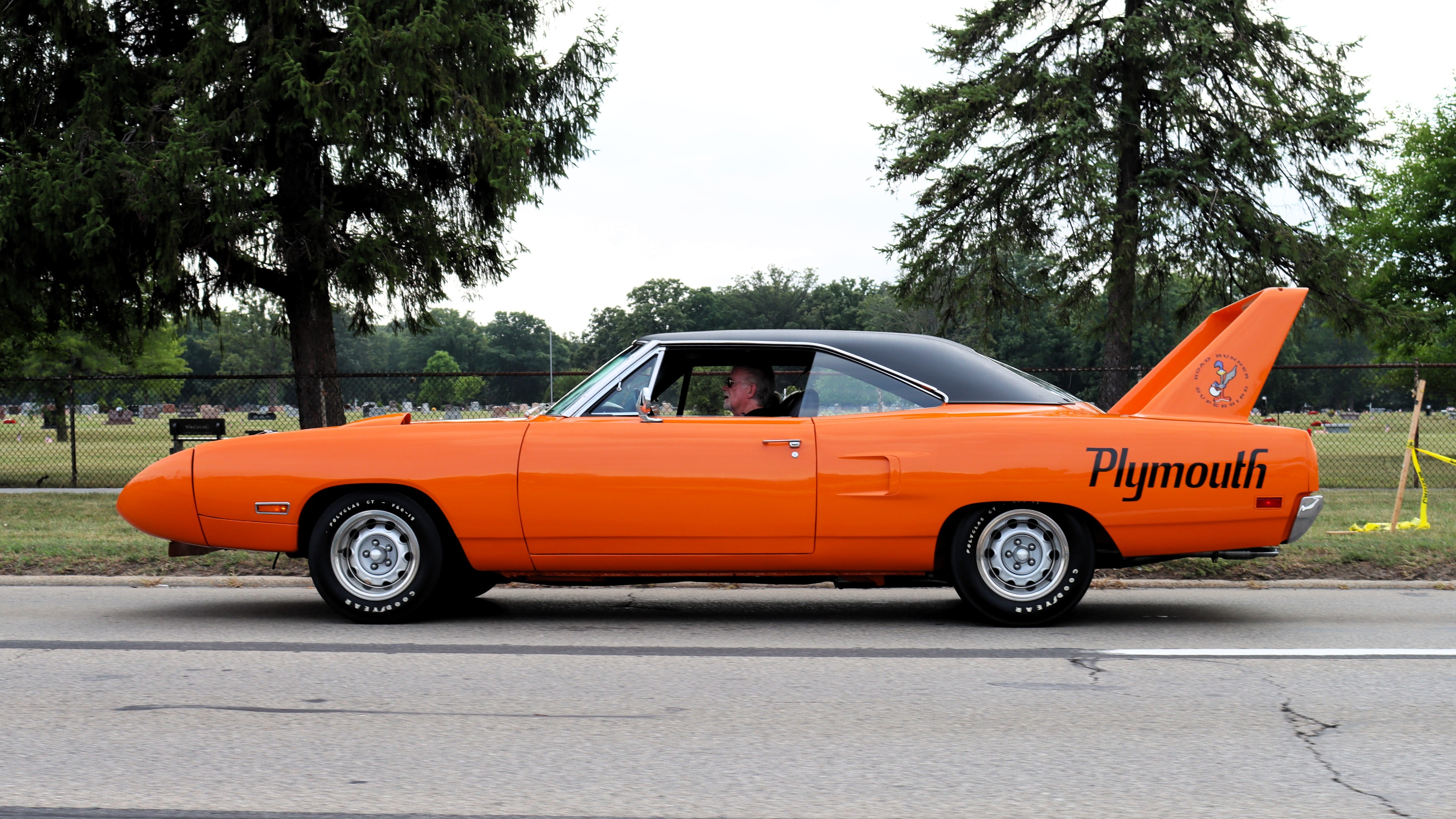 Photograph of a bright orange Plymouth Superbird seen from the left side.